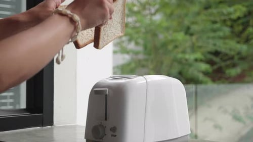 Hands Put Toaster Bread in White Toaster and Turn on a Toaster