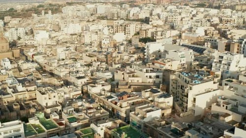 Beige Brown Apartment Blocks in Hot Area in Sunlight on Malta Island, Aerial Drone Forward Tilt Down