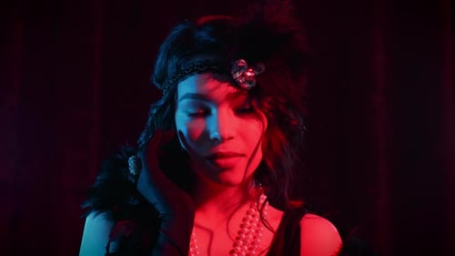 Portrait of Woman Dressed in Style of Great Gatsby Flirting and Posing on Dark