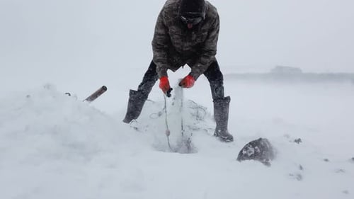 Fisherman Ice Fishing on the Lake