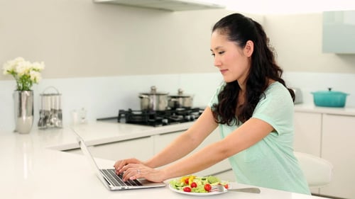 Woman Eating Salad While Working at Home