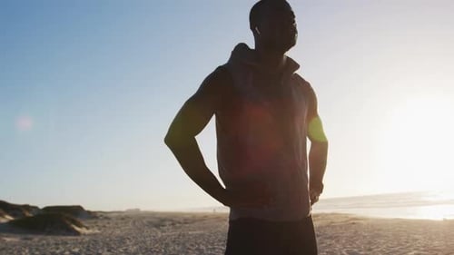 Athletic Man Stretching on Beach at Sunrise