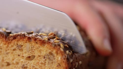 Close Up of Knife Cutting Homemade Bread