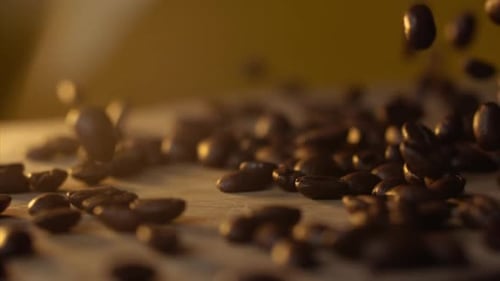 Frische Kaffeebohnen fallen in Slowmo auf den Tisch