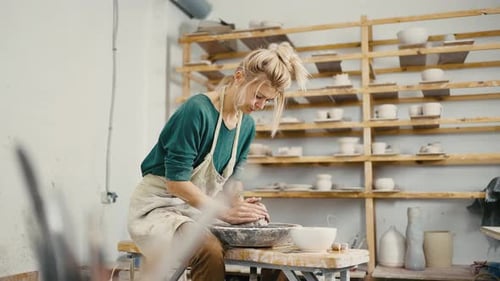 Woman Artist Shaping Clay on Pottery Wheel and Spinning It Working at Studio Tracking Shot Slow