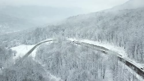Drones Eye View Winding Road From the High Mountain Pass in Winter