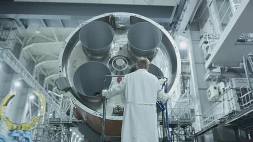 Engineer Inspects Rocket Engine in Manufacturing Facility