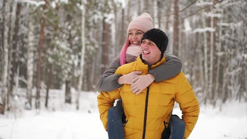Happy Loving Couple Walking in Snowy Winter Forest, Spending Christmas Vacation Together. Outdoor