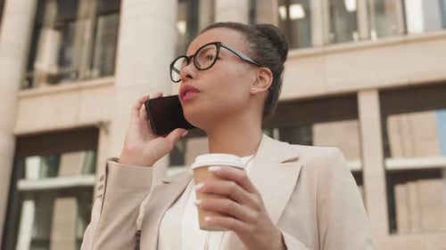 Woman Talks on Phone Outside Business Building