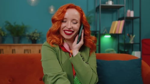 Woman Talking on Cell Phone on Orange Couch
