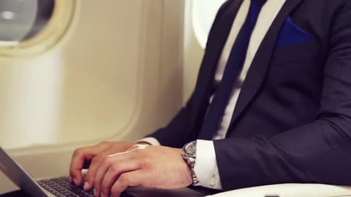 Professional Man Works on Laptop During Plane Flight