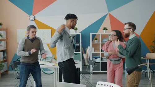 Diverse Group of Young People Colleagues Dancing in Office Having Fun Together