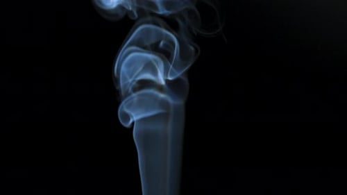 Abstract Smoke Rises Up in Beautiful Swirls on a Black Background