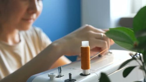 Winding Orange Thread on Sewing Machine Spool