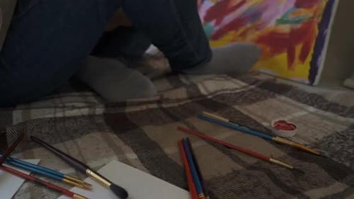 The Artist Paints on Canvas and Smears a Brush. Canvas Stands on the Easel.