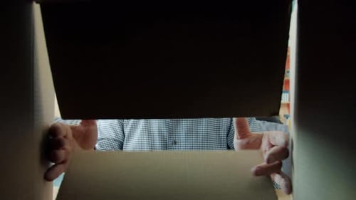 Slow Motion of Cheerful Old Man in Glasses Opening Carton Box Smiling Looking Inside