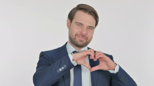 Young Businessman showing Heart Shape by Hands on Green Background