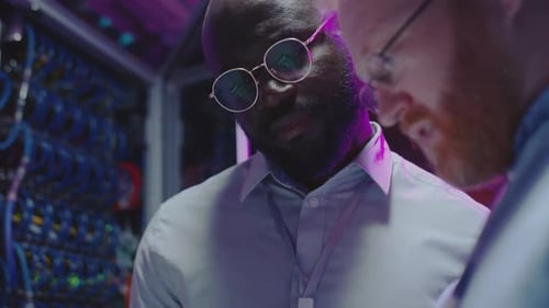 Mutliethnic Colleagues Working with Tablet in Data Center