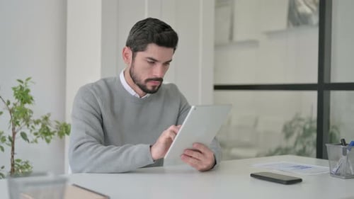 Young Man Using Tablet While Sitting in Office