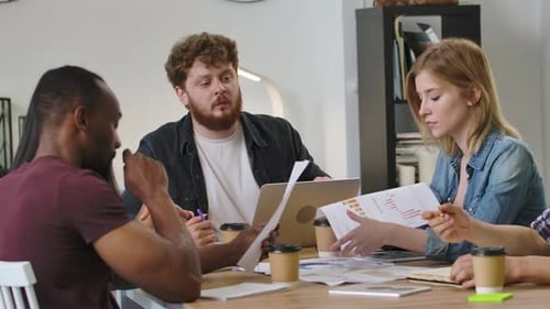 Une équipe sympathique et diversifiée discute d'un projet de démarrage