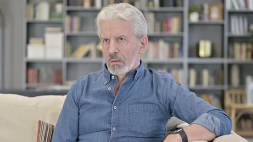 Ungeduldiger wartender alter Mann schaut auf Smartwatch
