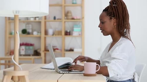 Side View of Young Woman is Working with Laptop at Table in Home Office During Quarantine Spbi