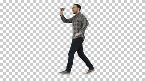 Young man taking photo with smartphone while walking, Alpha Channel