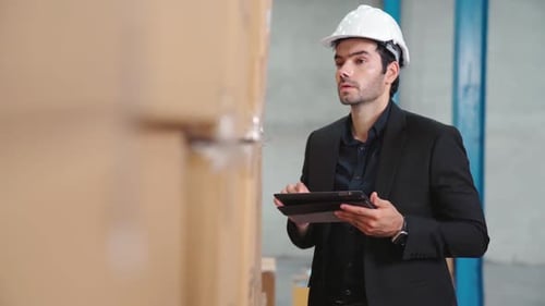 Factory Manager Using Tablet Computer in Warehouse or Factory
