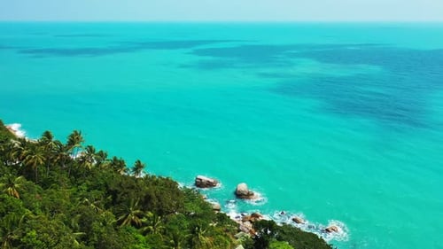 Aerial drone shot panorama of tranquil coast beach lifestyle by aqua blue lagoon with white sandy ba