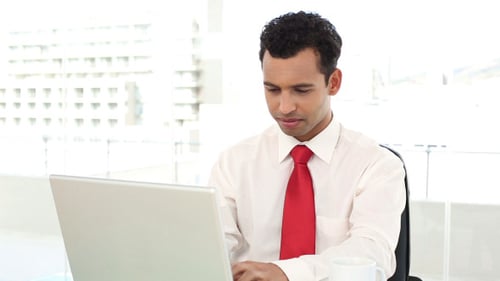 Man Working on Laptop and Drinking Coffee