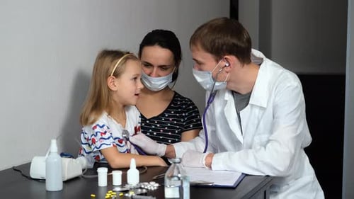 Doctor Examining Child with Stethoscope in Clinic