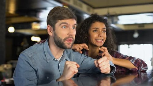 Friends Watching Sports at Bar in Excitement