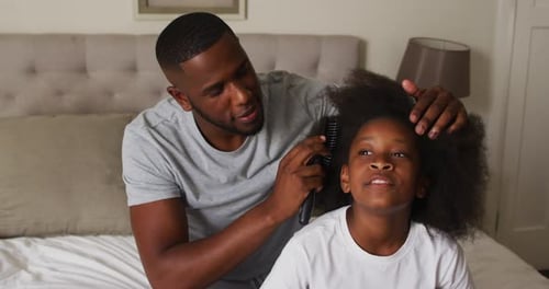 Caring Father Combing Child's Hair in Bedroom