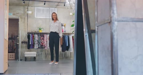 Linda garota elegante sai do provador e admira na frente de um grande espelho