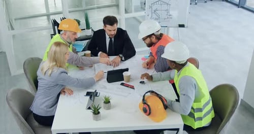 Un equipo de ingenieros y su jefe barbudo que intercambian ideas juntos