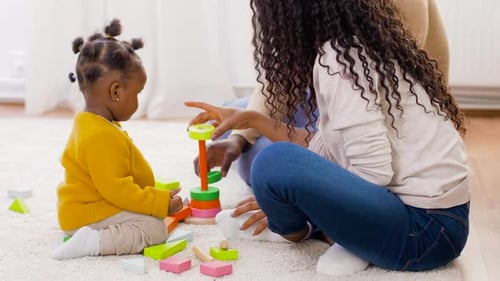 Parent and Baby Playing with Colorful Wooden Toys