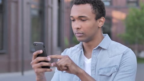 Young Adult Using Mobile Phone in City