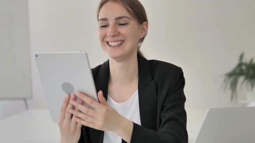 Woman Using Tablet for Video Call at Work