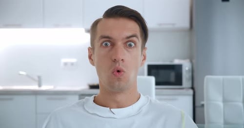 Excited Man Reacting Positively in Bright Kitchen