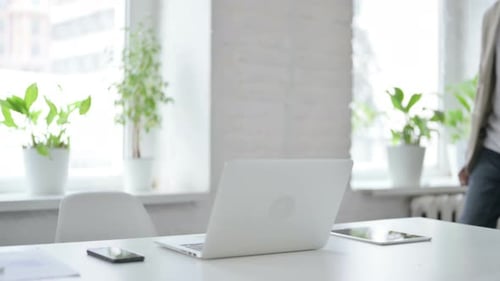 African Man Coming Back Opening Laptop in Office