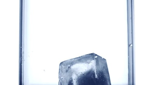 Ice Cubes Fall Into Clear Glass