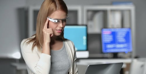 Woman Using AR Glasses and Laptop in Office