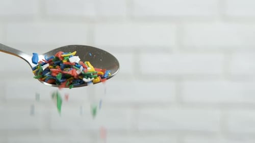 Close up of plastic falling from silver spoon