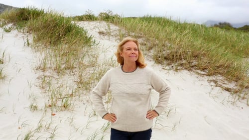 Smiling Retired Woman Standing On The Beach