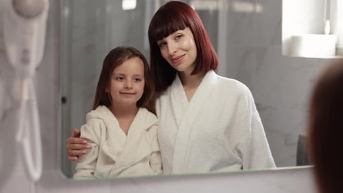 Mother and Child Smiling in Bathroom Mirror