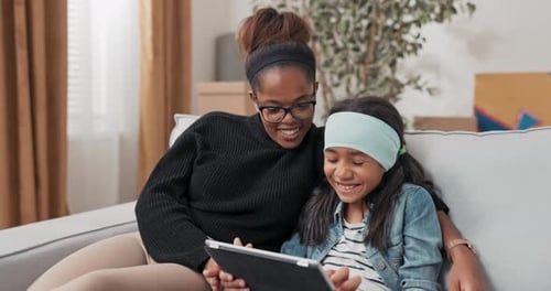 Schoolage Girl Sits on Couch Shows Mom Inspiration for Her New Room Plays Games Browses Internet on