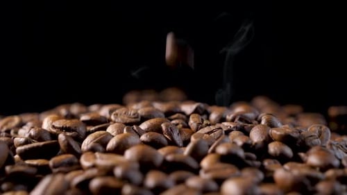 Roasted Coffee Beans Falling with Steaming Smoke