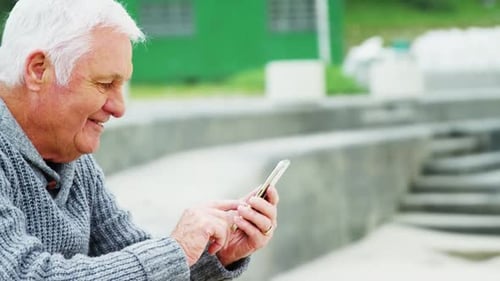 Senior man using mobile phone on beach