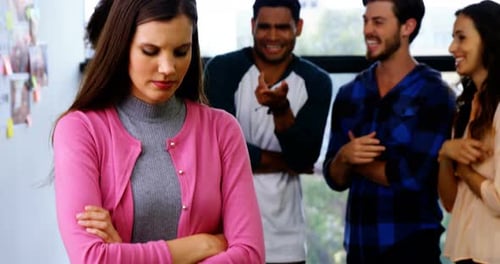 Colleagues bullying a sad female executive