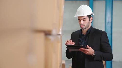 Factory Manager Using Tablet Computer in Warehouse or Factory